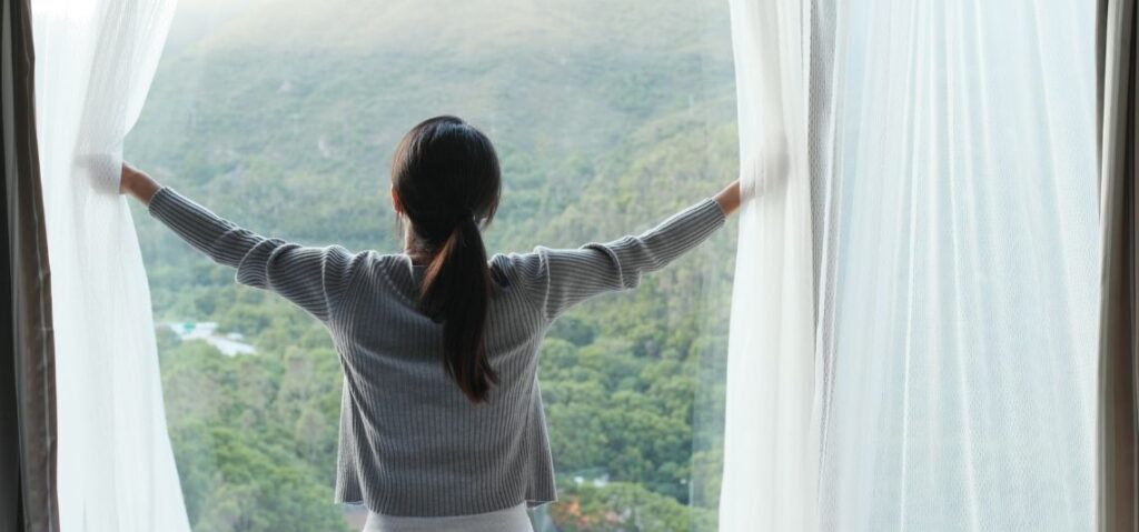 mujer abriendo una ventana