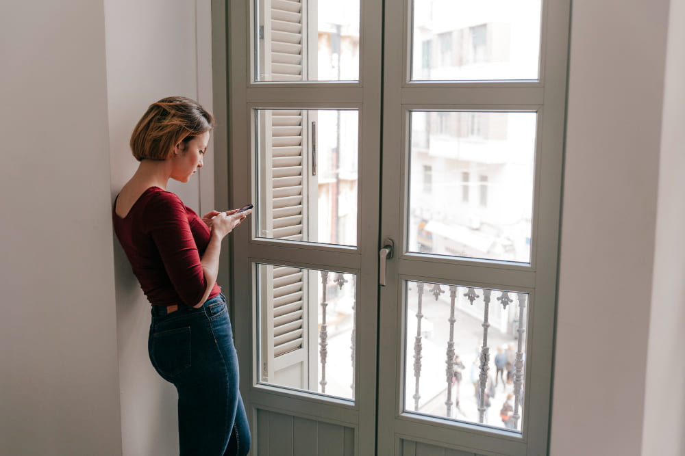 Modelos de ventanas de aluminio mujer apoyada vistas ciudad alto