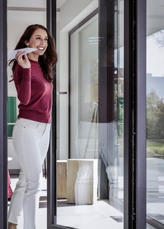 Chica sonriente frente a un cerramiento de cristal